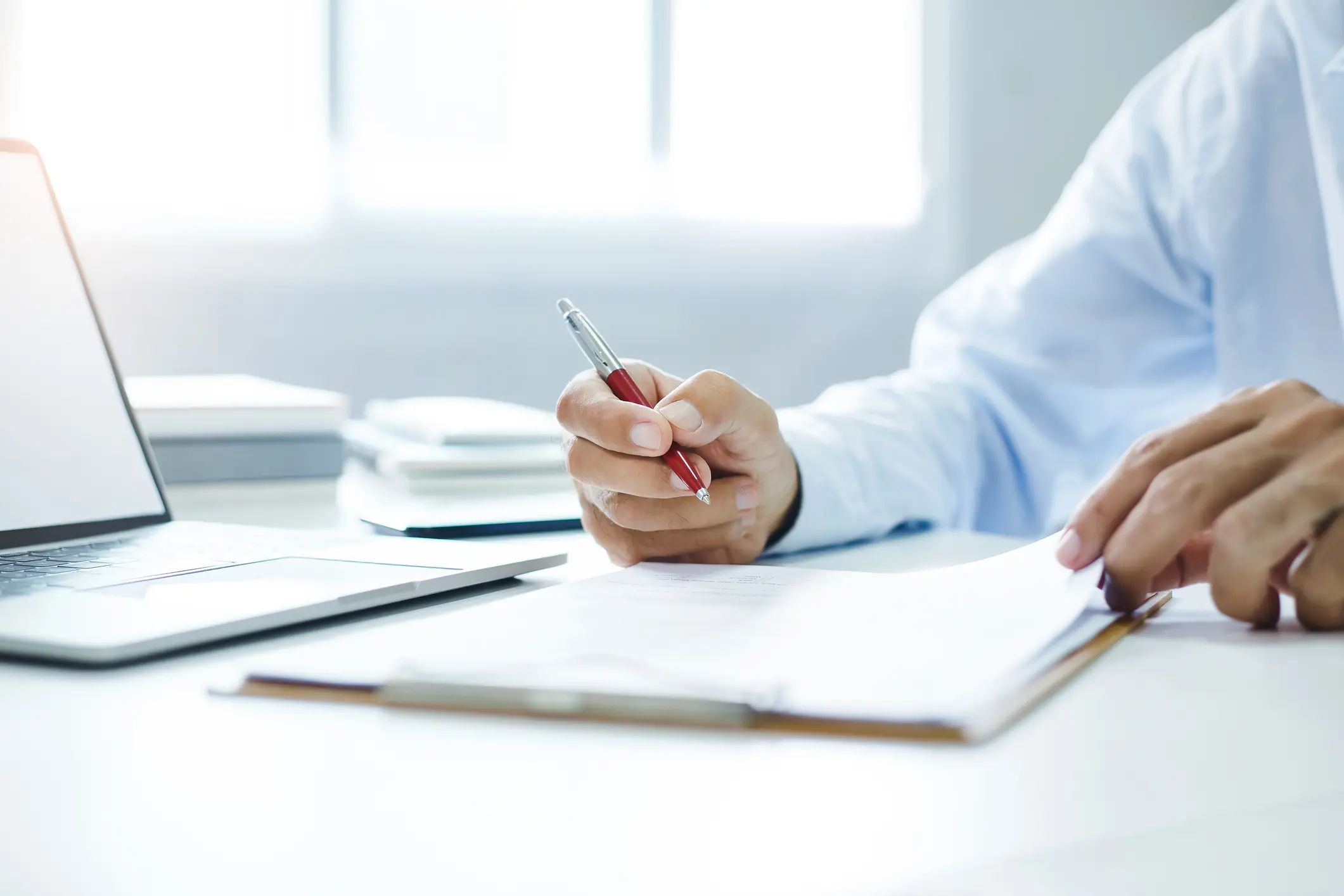 businessman reviewing document reports at office workplace with computer laptop. legal expert, professional lawyer reading and checking financial documents or insurance contract