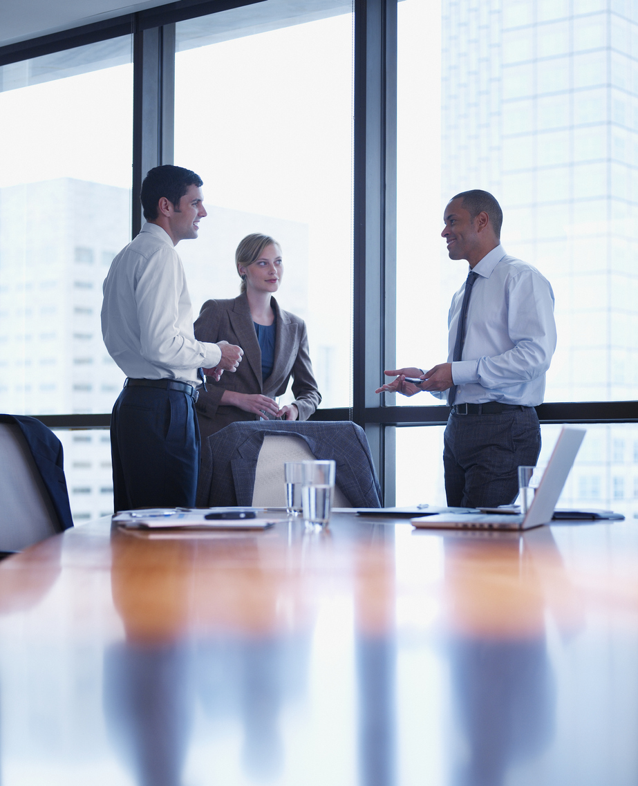 Three businesspeople standing in a boardroom